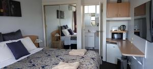 a small bedroom with a bed and a kitchen at White Manor Motel in Cooma