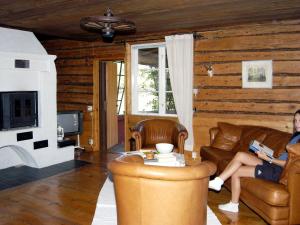 kobieta siedząca na kanapie w salonie w obiekcie 5 person holiday home in VÄDDÖ-By Traum w mieście Veda