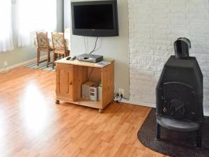 sala de estar con TV y estufa de leña en Two-Bedroom Holiday home in Farstad 1, en Farstad