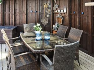 una mesa de cristal y sillas en un patio en Four-Bedroom Holiday home in Farstad, en Farstad