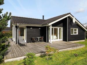 Brovstにある6 person holiday home in Brovstの庭に木製のデッキがある黒い家