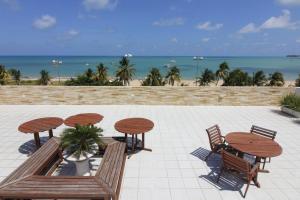 een patio met een tafel en stoelen en het strand bij Imperial Flat in João Pessoa