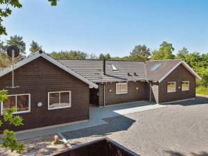 een bruin huis met een oprit ervoor bij 22 person holiday home in Nex in Bedegård