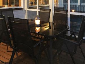 een tafel en stoelen op een veranda met een kaars bij 8 person holiday home in Auklandshamn in Vestvik