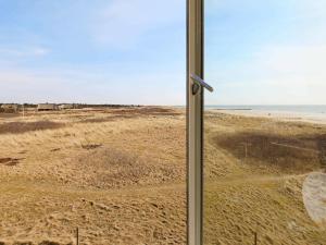 una vista del desierto desde una ventana de un campo en 6 person holiday home in Bl vand, en Blåvand