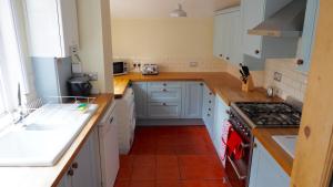 a kitchen with white cabinets and a stove top oven at Self contained stylish city home in Norwich