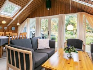 - un salon avec un canapé et une table en bois dans l'établissement Three-Bedroom Holiday home in Hals 33, à Øster Melholt