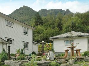 a house and a house with mountains in the background at 11 person holiday home in Syvde in Myklebost
