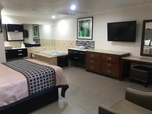 ein Hotelzimmer mit einem Bett, einer Badewanne und einem TV in der Unterkunft Economy Inn LAX Inglewood in Inglewood