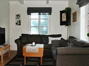 a living room with a couch and a table at Three-Bedroom Holiday home in Vågland in Bårdset