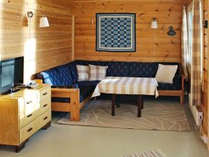 a living room with a couch and a tv at 5 person holiday home in VÅGLAND in Bårdset