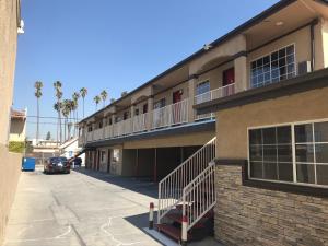 a building with a balcony and a parking lot at Lotus Motel in Inglewood