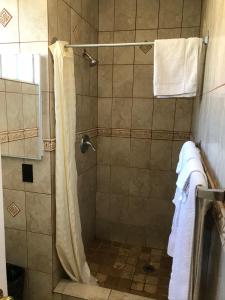 a bathroom with a shower with a shower curtain at Lotus Motel in Inglewood