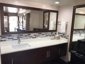 baño con lavabo y espejo grande en Economy Inn LAX Inglewood, en Inglewood