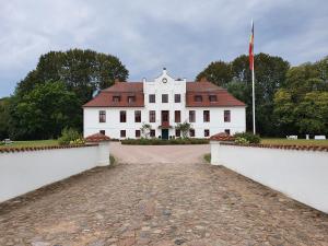 a large white house with a red roof at Wohnung in Satow mit Garten in Gerdshagen