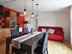 een woonkamer met een tafel en een rode bank bij Villa with pool in L zignan Corbi res in Lézignan-Corbières