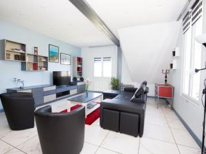 uma sala de estar com cadeiras pretas e uma mesa em Modern house with private terrace em Quinéville