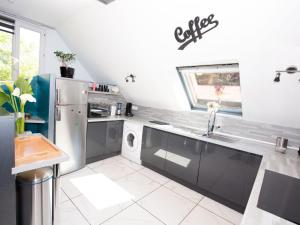 eine Küche mit einem Kühlschrank aus Edelstahl und einem Geschirrspüler in der Unterkunft Modern house with private terrace in Quinéville