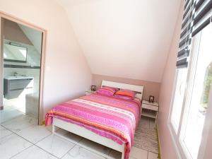 a small bedroom with a bed and a mirror at Modern house with private terrace in Quinéville