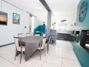 a kitchen and dining room with a table and chairs at Modern house with private terrace in Quinéville