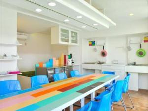 
a kitchen with a table, chairs, and a refrigerator at Khaosan Tokyo Laboratory in Tokyo
