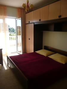 a bedroom with a large bed and a large window at Apartment in Rab/Insel Rab 16488 in Mundanije