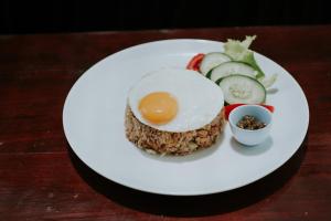 a white plate with an egg and vegetables on it at Beluran Panorama in Tabanan
