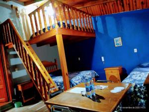 a room with a wooden staircase and a table and a bed at Hotel Plaza Mazamitla in Mazamitla