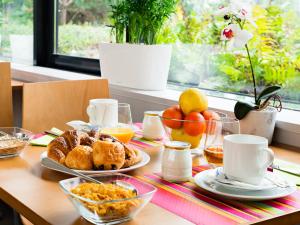 a table with breakfast food on a table with a window at Lagrange Apart’Hotel Paris-Boulogne in Boulogne-Billancourt