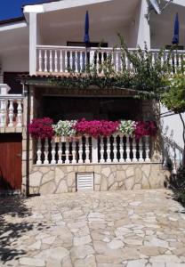 einen Balkon mit Blumen auf einem weißen Zaun in der Unterkunft Apartments Dobri - 500m from beach in Batalaži