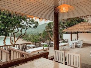 a restaurant with tables and chairs and a view of the beach at High Life Bungalow in Haad Yao