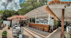 a restaurant with an outdoor bar with tables and chairs at High Life Bungalow in Haad Yao