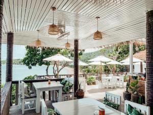 a patio with tables and chairs and umbrellas at High Life Bungalow in Haad Yao