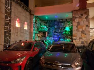 dos coches estacionados frente a un hotel meridiano en Hotel Manantial en Churín