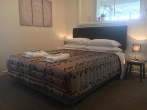1 dormitorio con 1 cama con 2 toallas en Gisborne Dream Suite en Gisborne