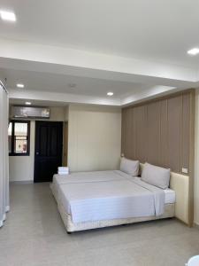 a bedroom with a large white bed in a room at The Shade Residence in Pattaya