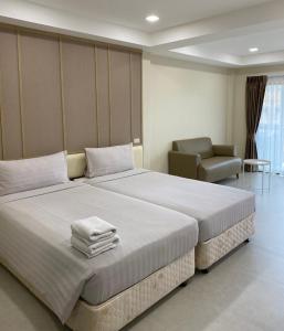 um quarto de hotel com uma cama grande e uma cadeira em The Shade Residence em Pattaya Central