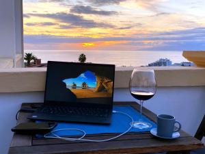 a laptop computer sitting on a table with a glass of wine at Dream View in Adeje