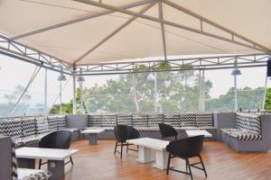 a restaurant with tables and chairs and windows at Kapal Garden Hotel at Rekreasi Sengkaling in Malang