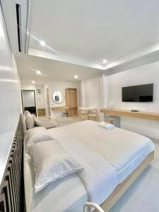 1 dormitorio blanco con 1 cama grande y TV de pantalla plana en Topnorth Hotel Maesai, en Mae Sai