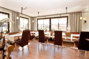 - une salle à manger avec des tables, des chaises et des fenêtres dans l'établissement Haus Leutner, à Bodenmais