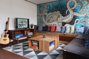 sala de estar con sofá y TV en Starfall Lodge en Hakuba
