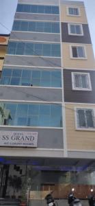 un edificio alto con un cartel delante en PPH Living SS Grand en Shamshabad