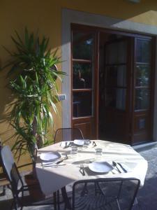 ルッカにあるB&B Il Casale di Nanniの白いテーブルと椅子、建物前の植物