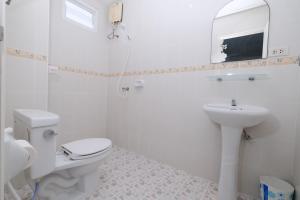 a white bathroom with a toilet and a sink at Kiwi Boutique Hotel in Patong Beach