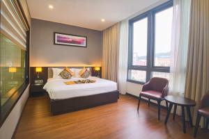 Un pat sau paturi într-o cameră la SK LEGEND VUNG TAU HOTEL