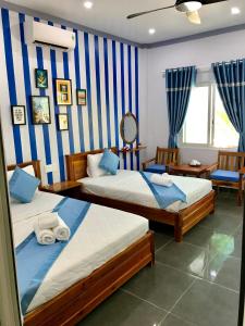 2 camas en una habitación con rayas azules y blancas en BIỂN ĐỒI Bungalow en Phu Quoc