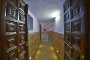 a hallway with two wooden doors and a staircase at Hotel Rang Sagar Haveli in Udaipur