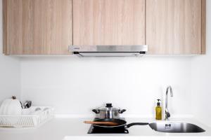 eine Küchentheke mit Topf und Spüle in der Unterkunft Tropicana 218 Macalister by Simply Penang in George Town + 74 Fotos