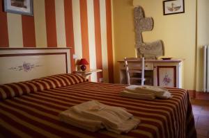 a bedroom with a bed with towels on it at B&B Anfiteatro in Lucca